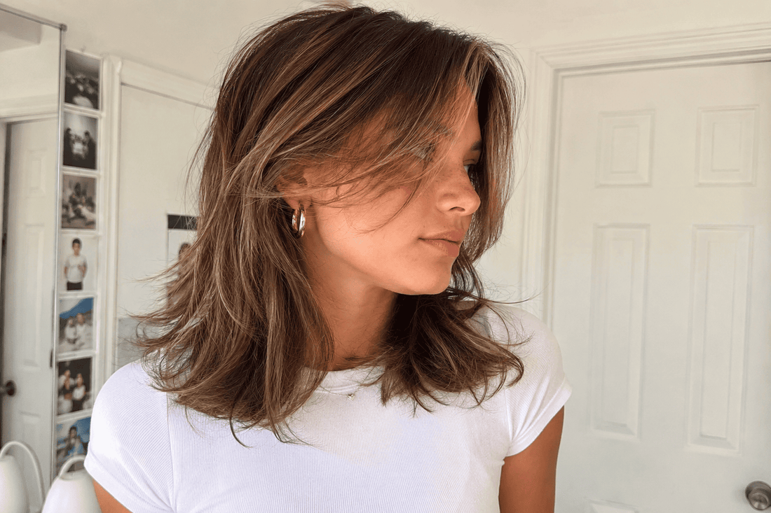 Woman with soft layered hair and face-framing highlights showing a lightweight, natural shine for a Lanese Beauty summer haircut blog.