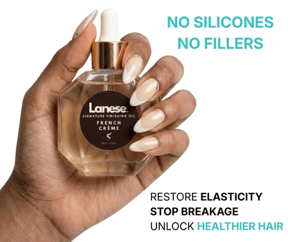 A close-up photo of a person’s hand with elegant French-tip nails holding a glass hexagonal bottle of Lanese Signature Finishing Oil in French Crème. To the right, teal and black text reads, "No Silicones, No Fillers. Restore elasticity, stop breakage, unlock healthier hair."