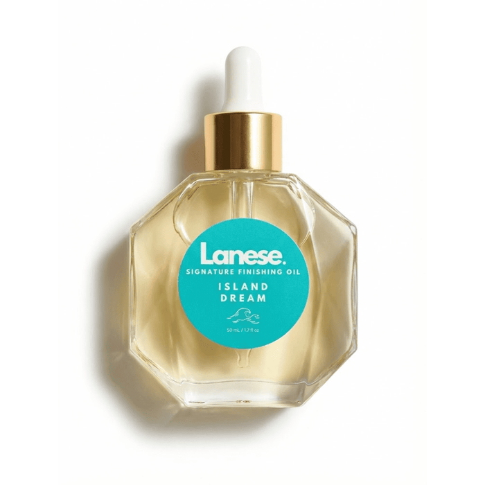 A clean product shot of the Lanese Island Dream Signature Finishing Oil bottle on a white background. The hexagonal glass bottle shows the golden oil inside and features a teal circular label with a minimalist wave illustration.