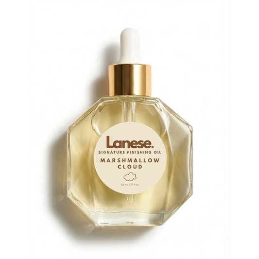 A hexagon-shaped glass dropper bottle of Lanese hair oil with a gold collar and white dropper bulb, set against a plain white background. The light beige label features a small cloud icon and reads: "Lanese. SIGNATURE FINISHING OIL. MARSHMALLOW CLOUD. 50 mL / 1.7 fl oz".