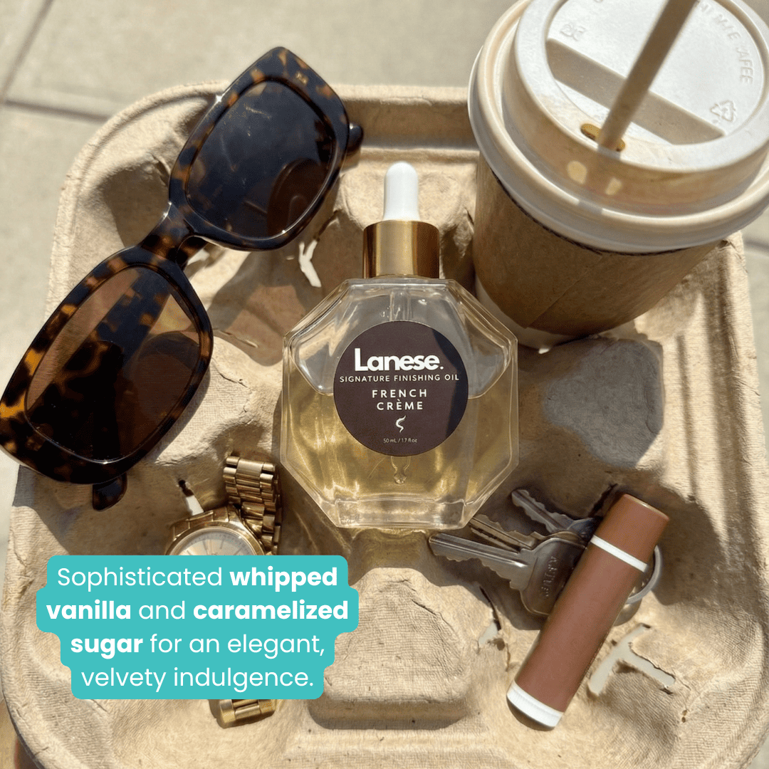 A lifestyle flat-lay of the Lanese oil bottle sitting in a cardboard drink carrier alongside a latte, tortoiseshell sunglasses, a gold watch, keys, and a lip balm. Text reads: "Sophisticated whipped vanilla and caramelized sugar for an elegant, velvety indulgence."