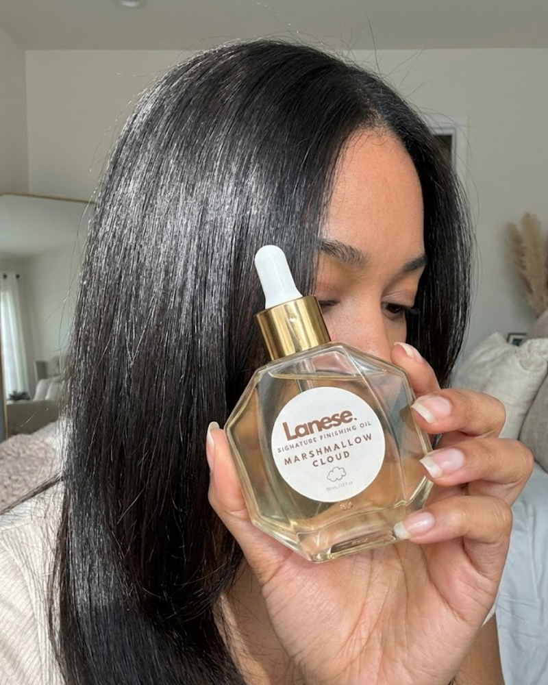 Person holding a bottle of Lanese hair product in front of their face